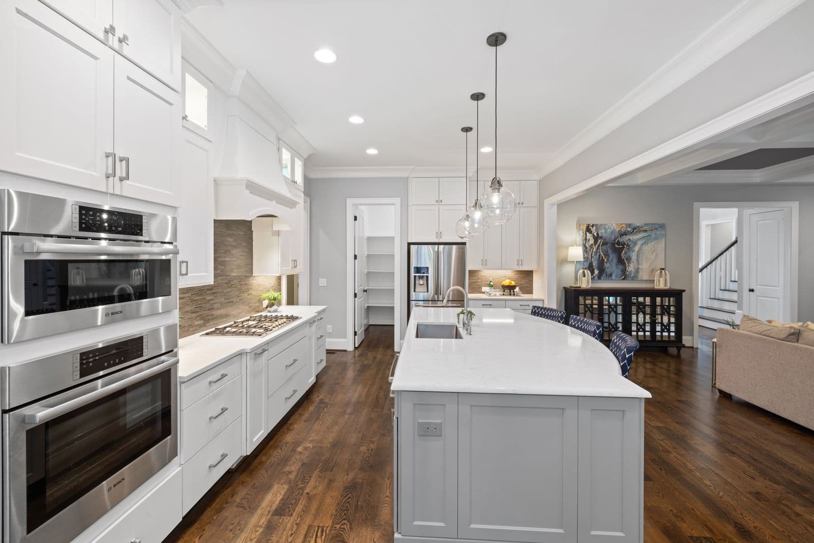 A remodeled kitchen with white cabinets, a large island, and stainless appliances